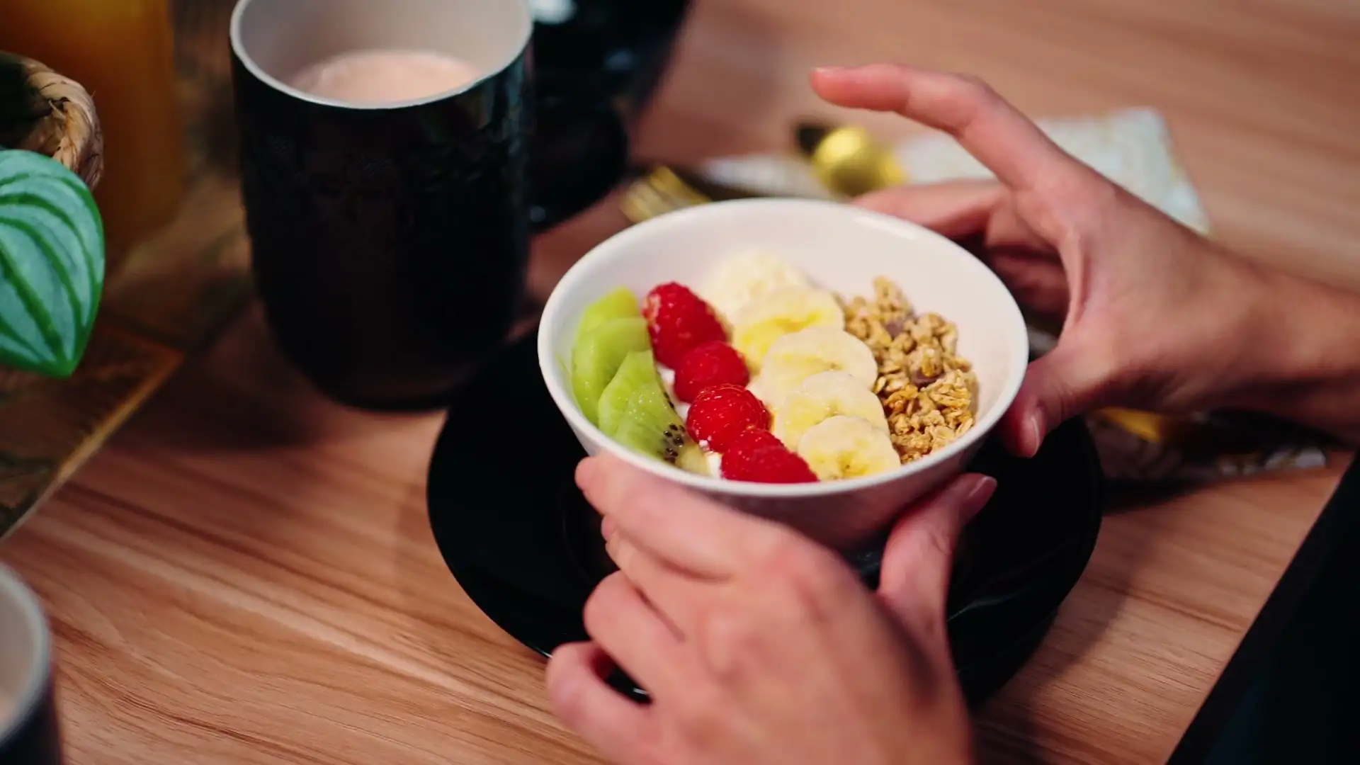 Bol de fruits frais et de granola, servi avec une boisson chaude