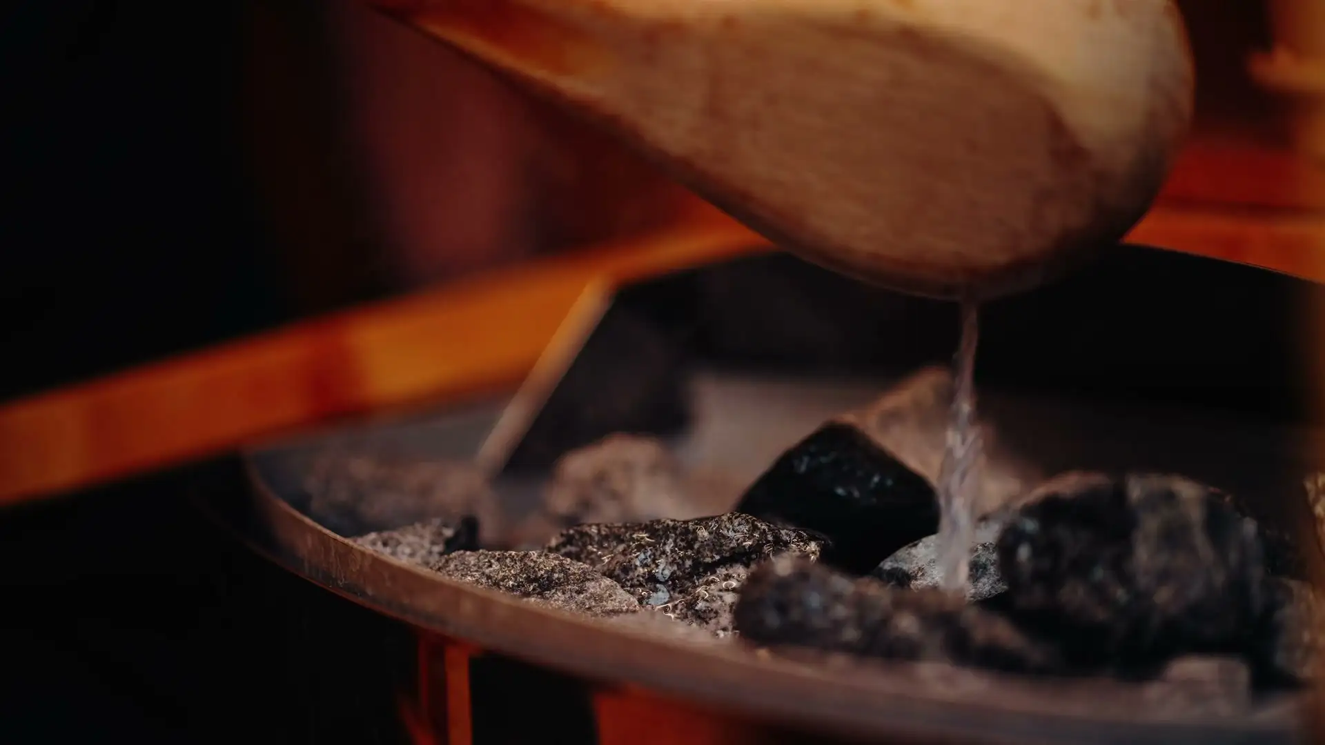 Eau versée sur les pierres chaudes du sauna extérieur