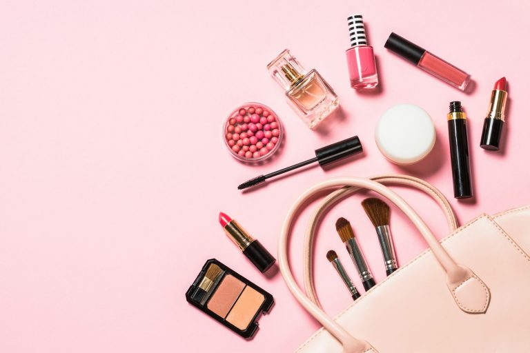 Woman flat lay makup background with cosmetics on pink